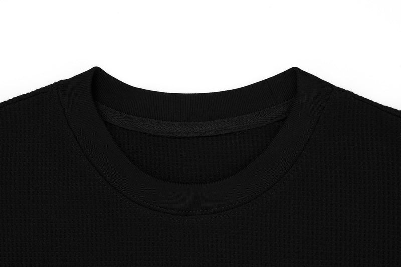 Close-up of layered crew neckline on black long sleeve tee showing inner collar detail