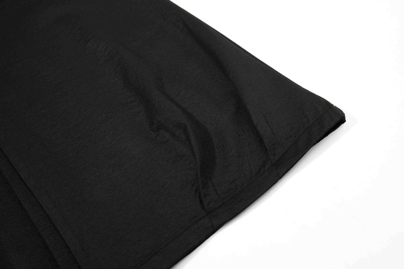 Close-up of black pant leg fabric and hem stitching with smooth matte texture