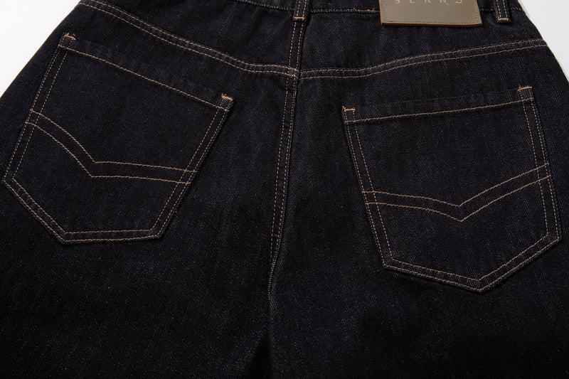 Back view close-up of dark wash jeans with two patch pockets and contrast stitching