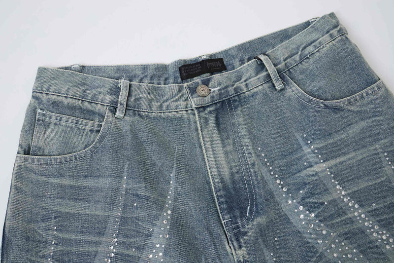 Close-up of light wash denim shorts waistband and front pocket with rhinestone detail