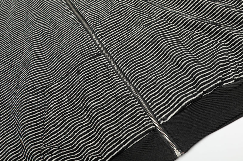 Close-up of black striped hoodie hem and front zipper