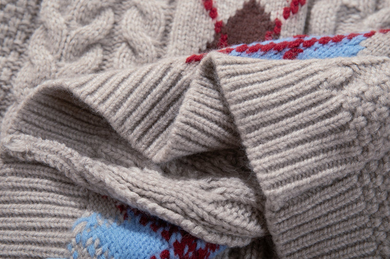 Close-up of beige sweater sleeve and cuff with argyle panel edge visible