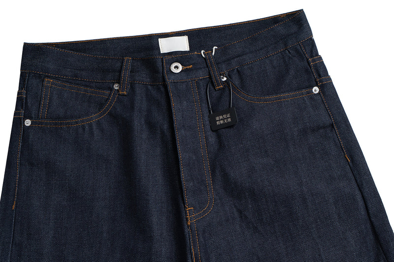 Waistband close-up of dark jeans with front pockets, button fly and hanging tag