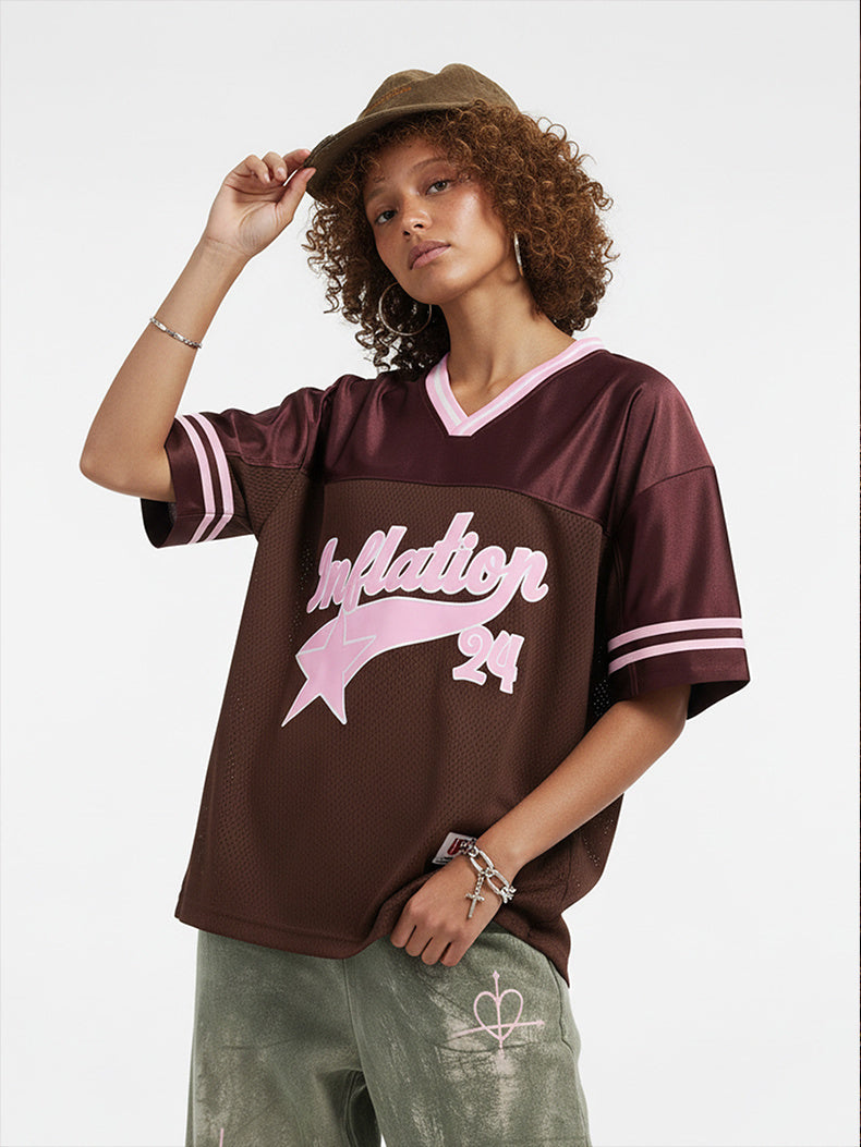 Model wearing a burgundy mesh varsity jersey with pink Inflation 24 graphics, striped sleeves, and a V-neck collar