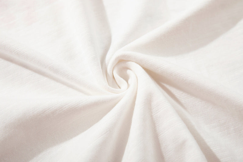 Close-up of soft white knit fabric with a smooth spiral fold, ideal for a minimalist Number (N)ine graphic T-shirt