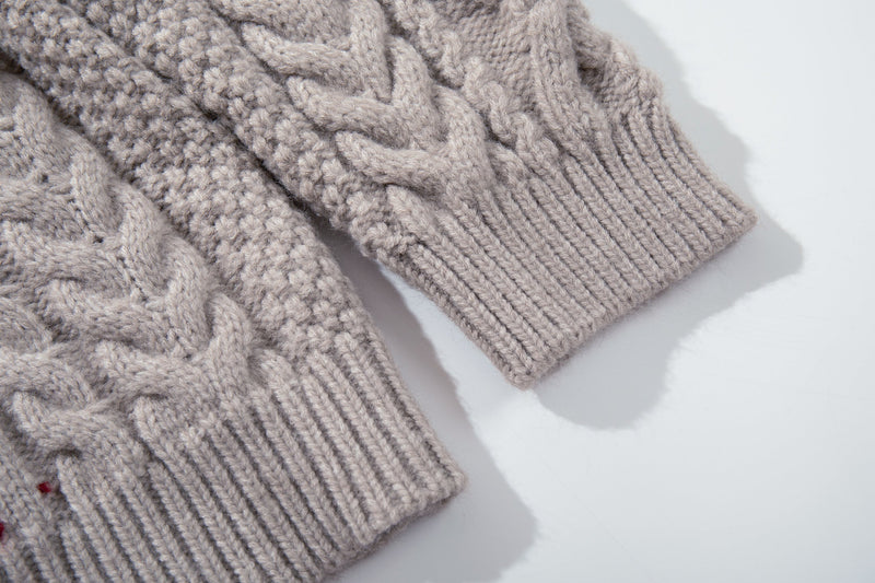 Close-up of ribbed sweater cuff and chunky cable knit sleeve in beige