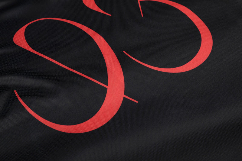 Black mesh jersey with bold red abstract portrait graphic and oversized streetwear styling
