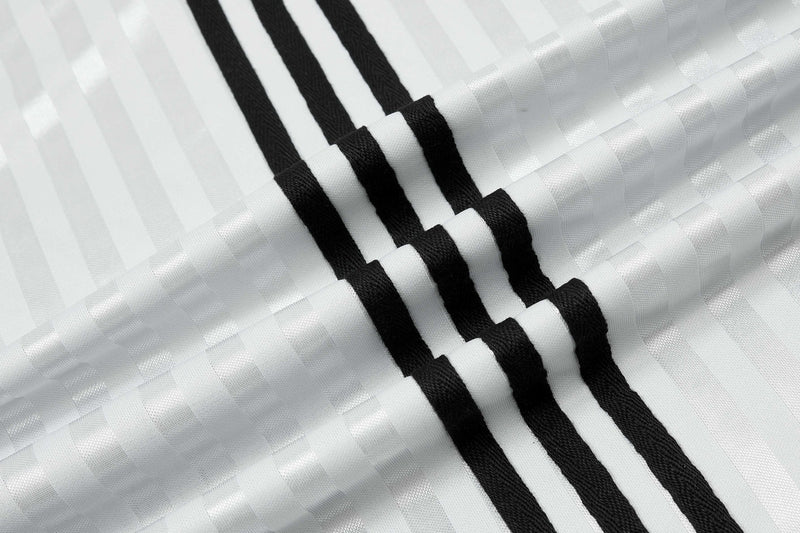 White retro football jersey fabric with bold black vertical stripes and a textured script stripe pattern