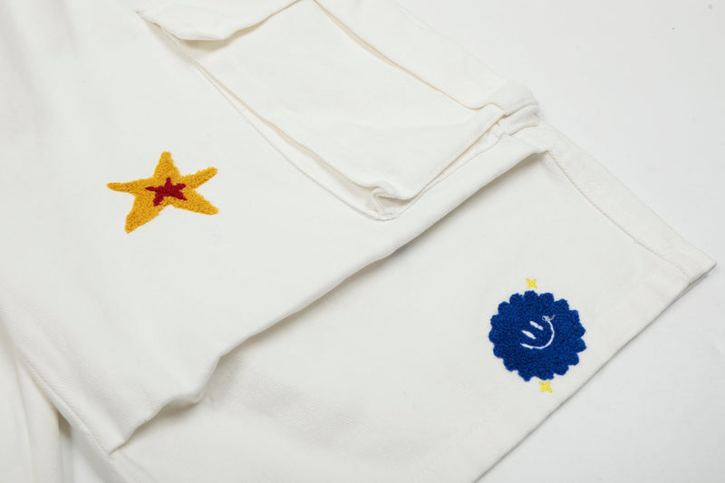 Close-up of white cargo shorts star patch and blue smiley patch