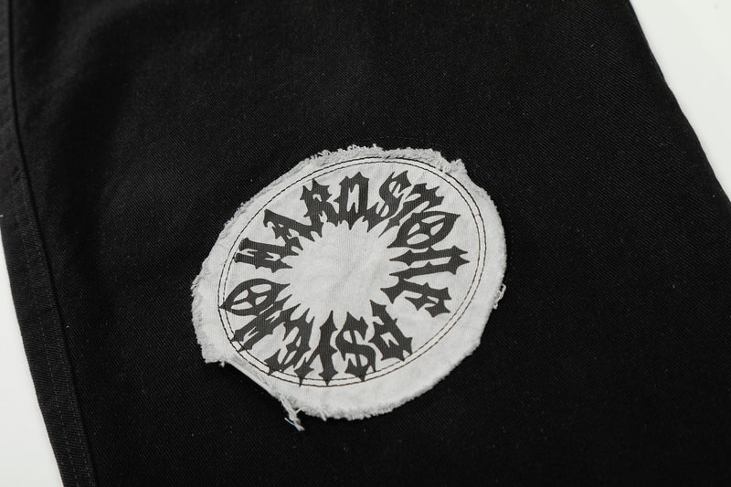 Close-up of circular white and black graphic patch on black pants
