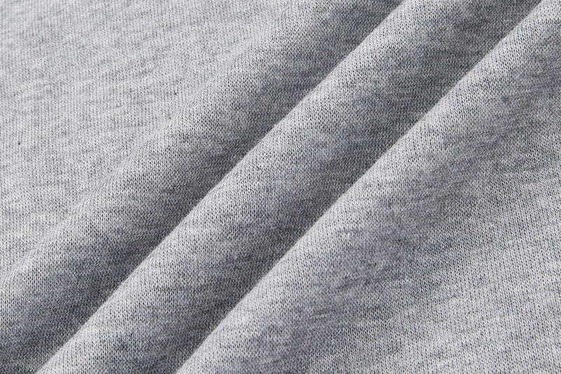 Close-up of light gray knit fabric with diagonal folds, showing the vintage Beatles graphic T-shirt material texture