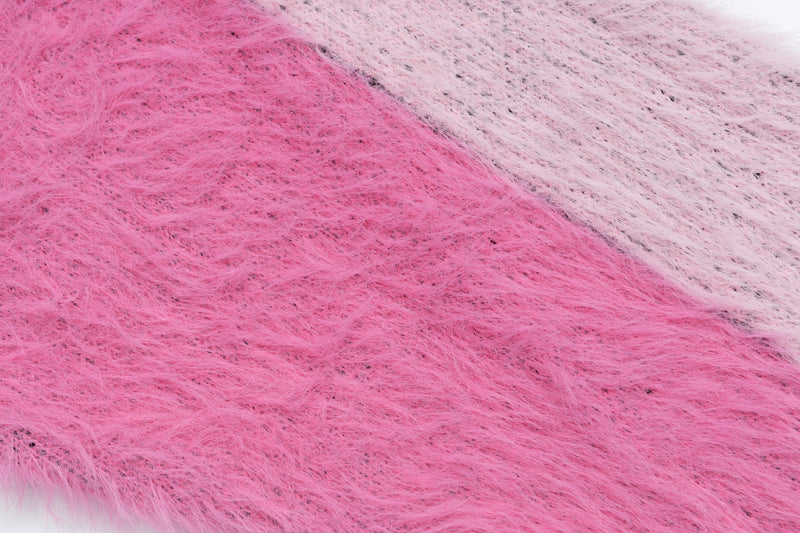 Close-up of pink fuzzy knit sweater fabric with one white section at the edge