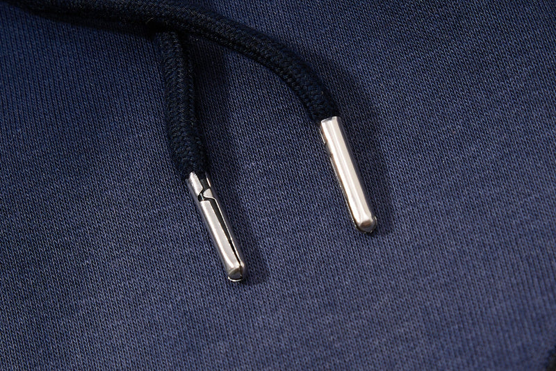 Close-up of navy drawstring tips on textured fabric waistband