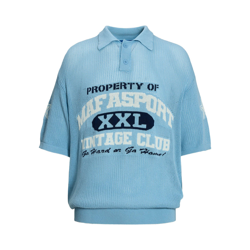 Light blue knit polo shirt with varsity-style text graphic and short sleeves on a white background