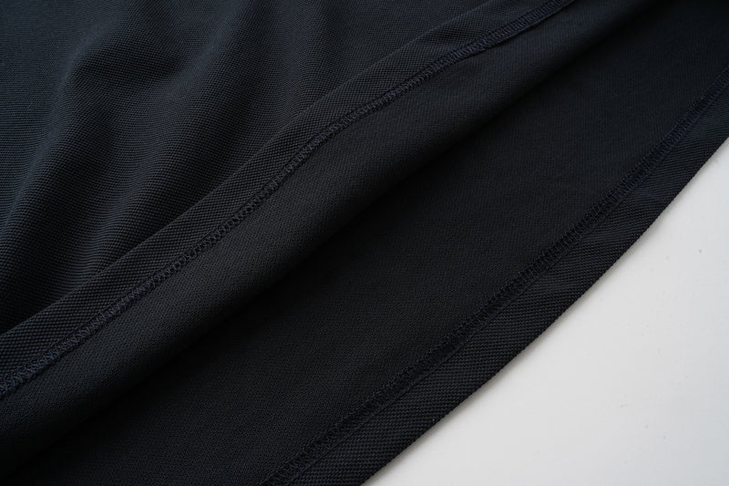 Black sleeve hem close-up with stitched cuff and soft knit texture