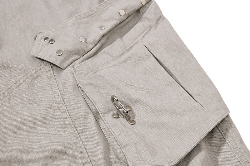 Beige cargo pocket close-up with snap flap and side buckle strap