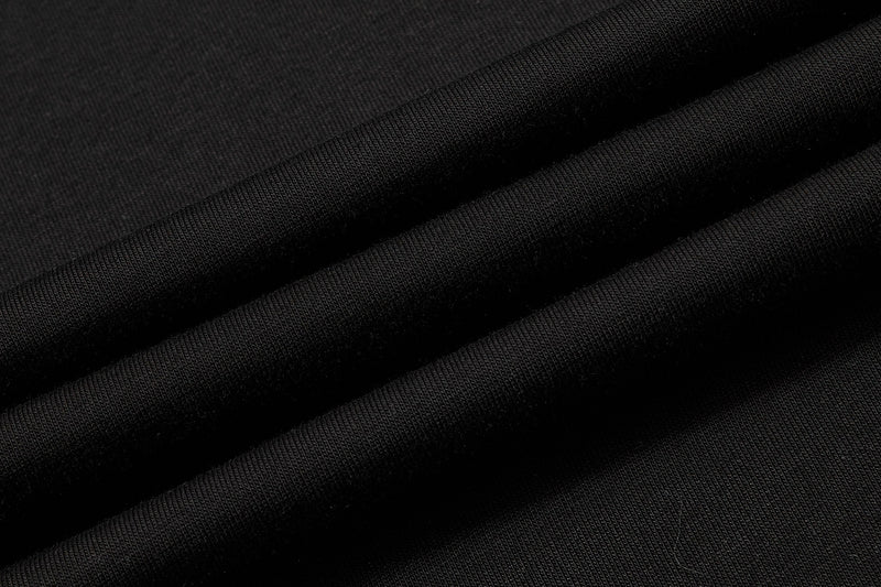 Close-up of black distressed polo shirt fabric with soft diagonal folds and textured knit weave