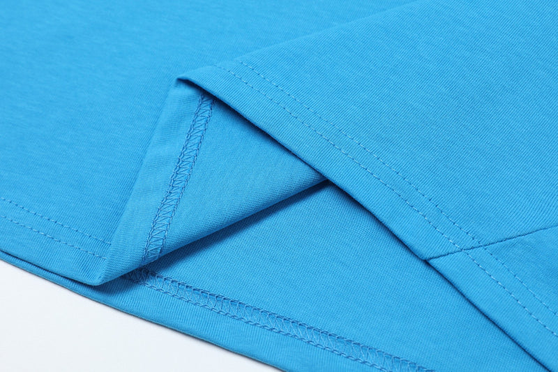 Close-up of a bright blue varsity jersey tee showing colorblock paneling and visible stitched hems