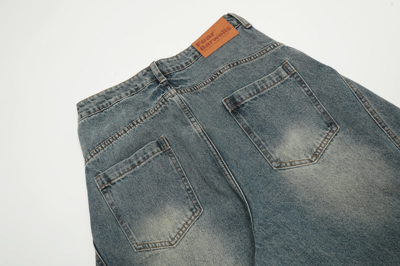 Back waist of vintage wash denim pants with patch label and pocket detail