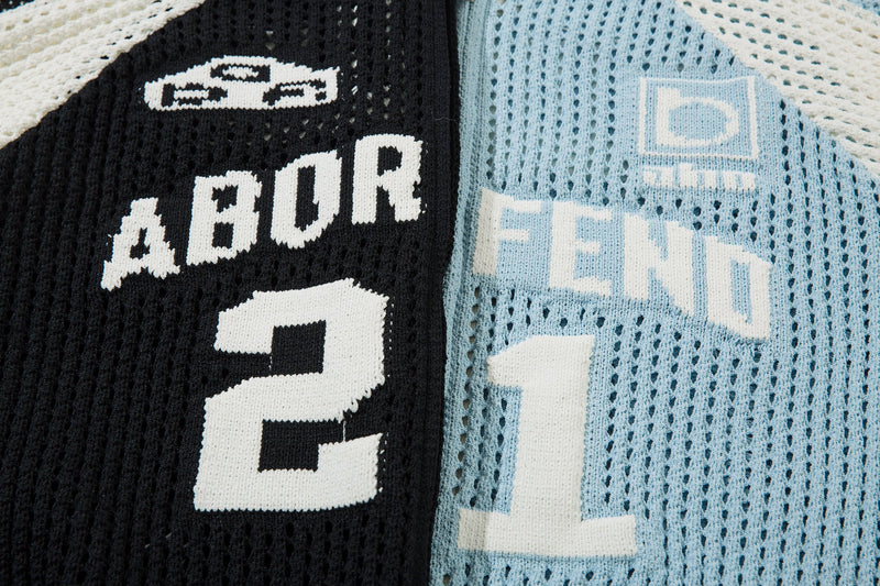 Close-up of light blue and black mesh knit jacket front lettering and chest logos