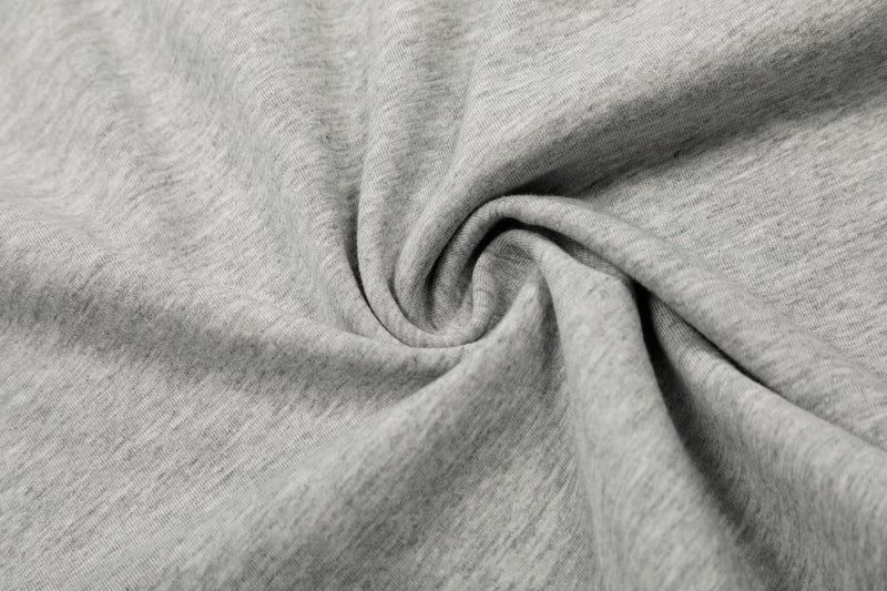 Close-up of soft gray cotton knit fabric with a smooth, textured weave and natural draped folds