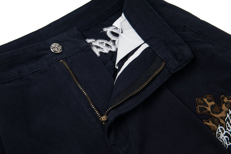 Black cargo pants waistband open at zipper with leopard cross patch detail