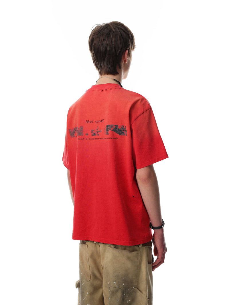 Back view of a red distressed graphic tee with black print, styled on a model with tan cargo pants