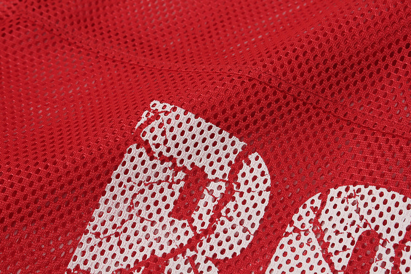 Close-up of a red oversized mesh football jersey with white printed number detail and breathable perforated fabric