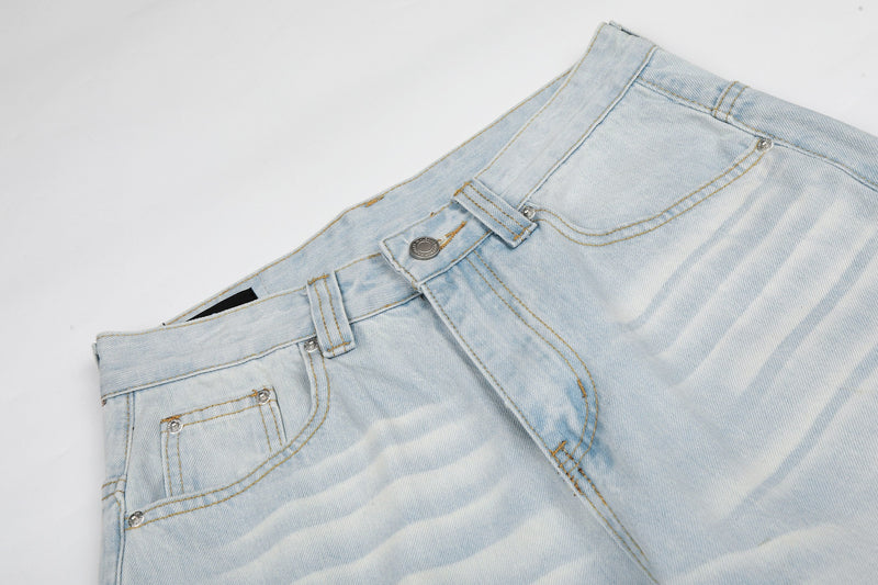 Top angled view of light wash jeans waist with button closure and front pockets