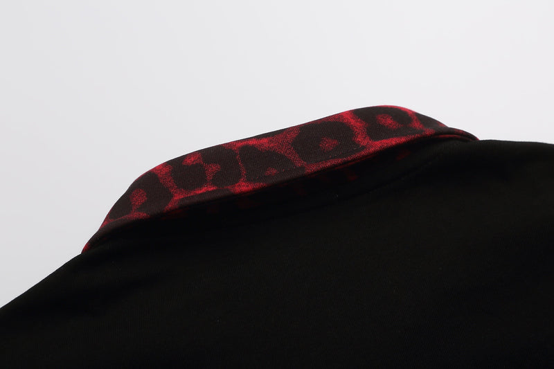 Black polo shirt with red leopard print collar on a clean white background