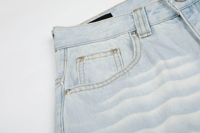 Close-up of front pocket and waistband on light wash denim jeans