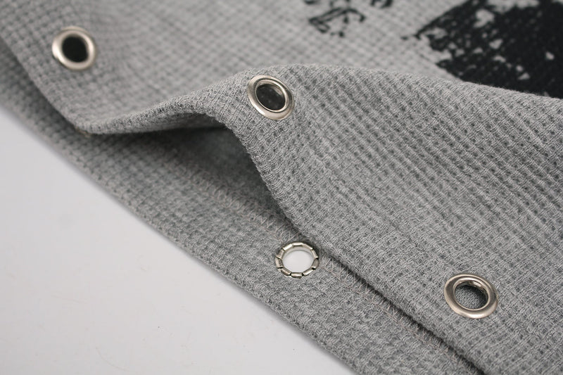 Gray gothic graphic tee cuff with metal grommet details and textured knit fabric close-up