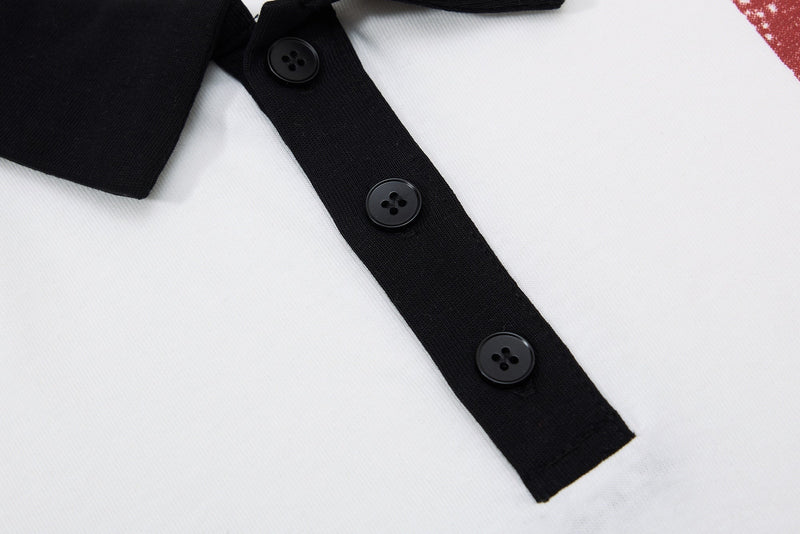 Close-up of a white men's polo shirt with black collar trim and buttons, featuring a vintage music graphic detail