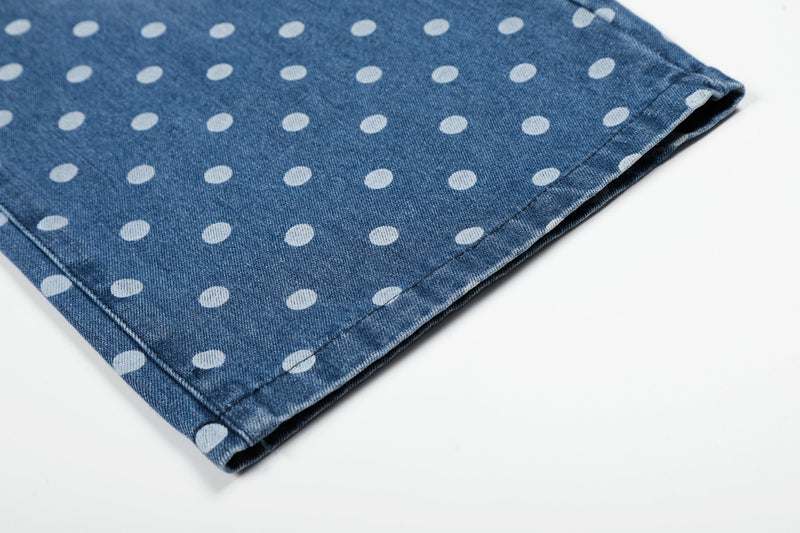 Close-up of the hem on blue wide-leg jeans with white polka dots