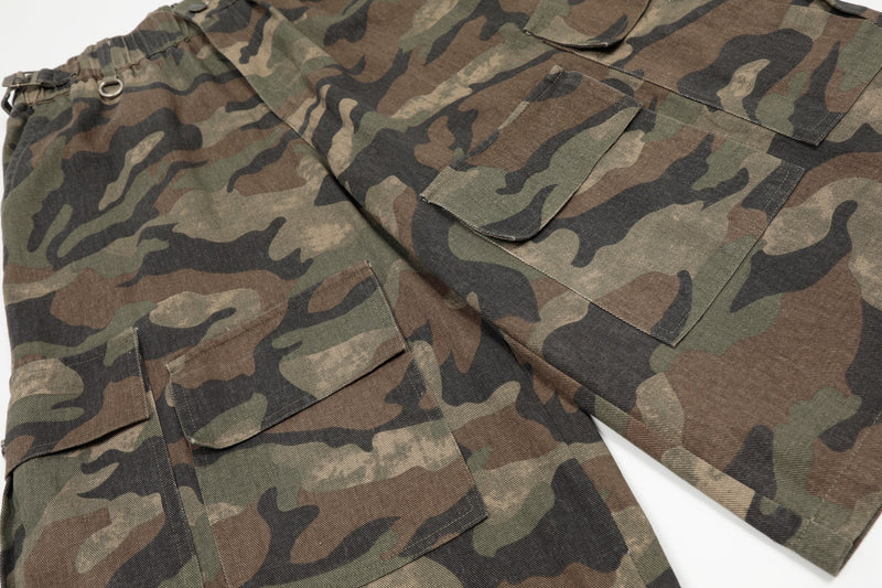 Close-up of front and back cargo pockets on green brown camouflage shorts
