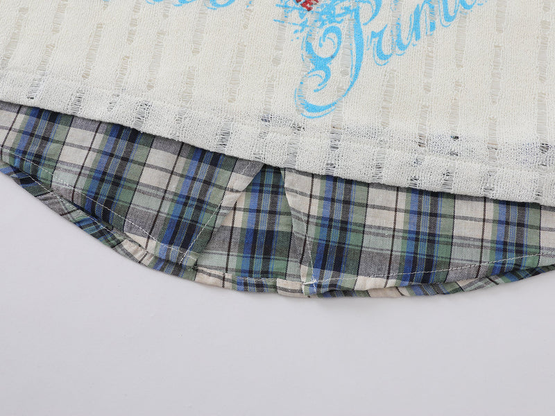 Close-up of curved plaid hem under cream distressed shirt with layered shirt tail detail
