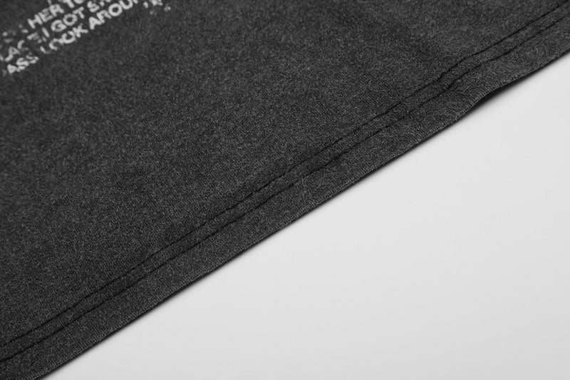 Washed charcoal graphic tee with a vintage fade and raw hem detail on soft cotton fabric