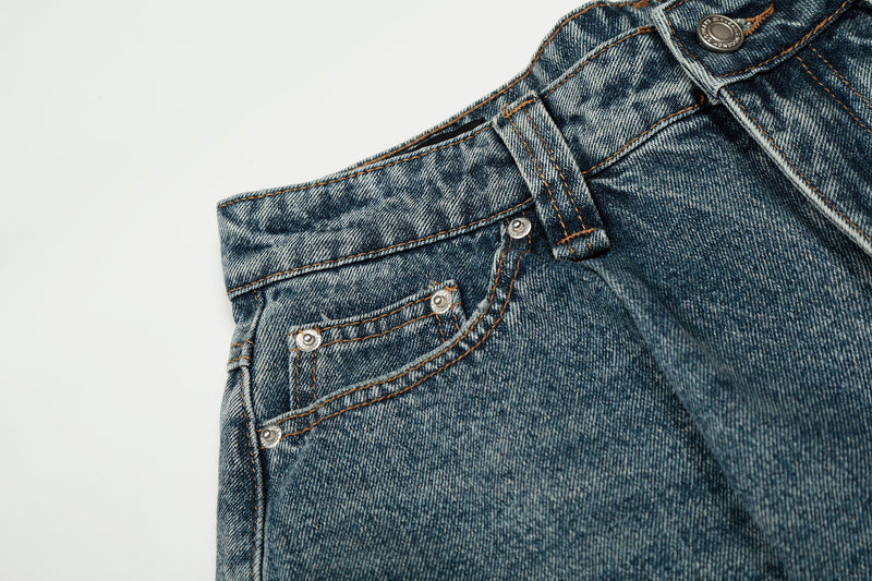 Close-up of front left pocket and waistband on blue jeans with contrast stitching