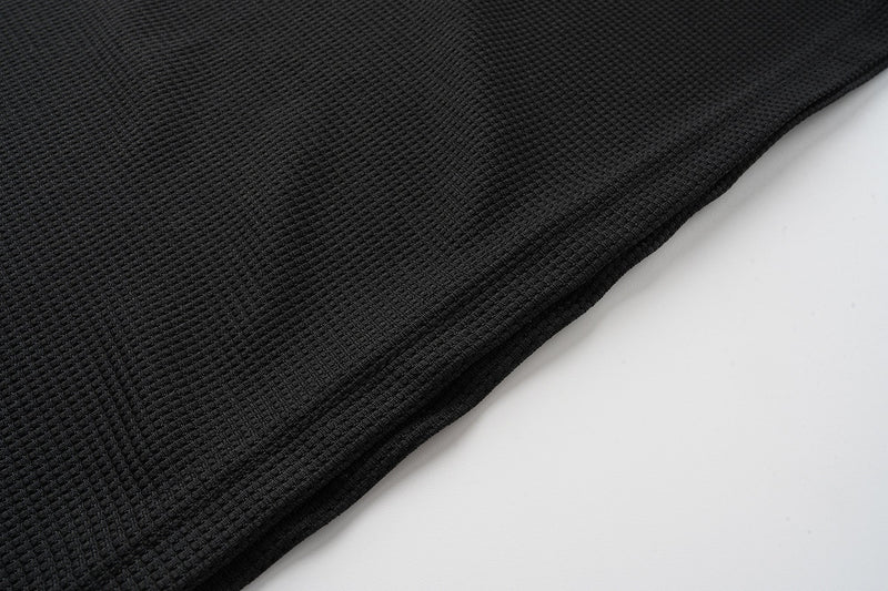 Close-up of black waffle-knit shirt fabric texture