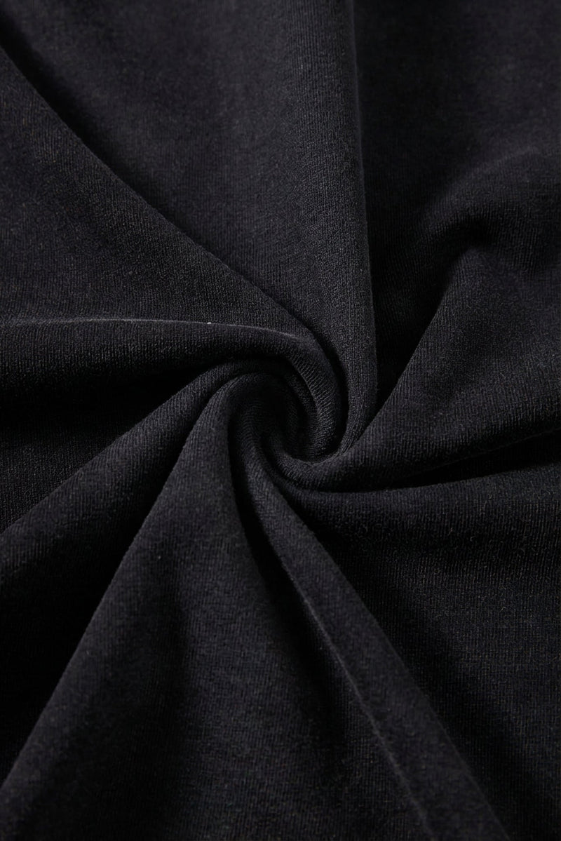 Close-up of black washed cotton fabric with soft texture and spiral folds for a boxy streetwear T-shirt