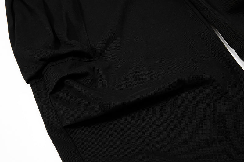 Black cargo pants leg close-up with smooth fabric and seam detail