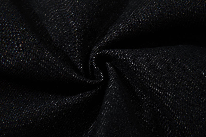 Close-up of black denim fabric texture with a soft folded drape