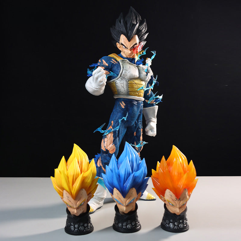 The Seakoff Vegeta Collectible Figure from Dragon Ball Z stands on display, featuring spiky black hair and battle-damaged attire, accompanied by four interchangeable Super Saiyan heads with yellow, blue, and orange hair, all with stern expressions.