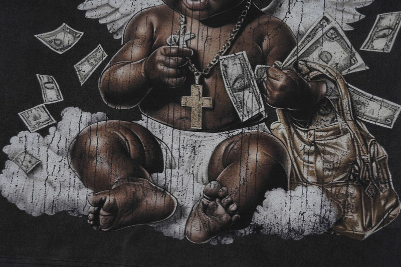 Vintage wash graphic T-shirt featuring a cherub with chain and cross, surrounded by floating dollar bills and clouds