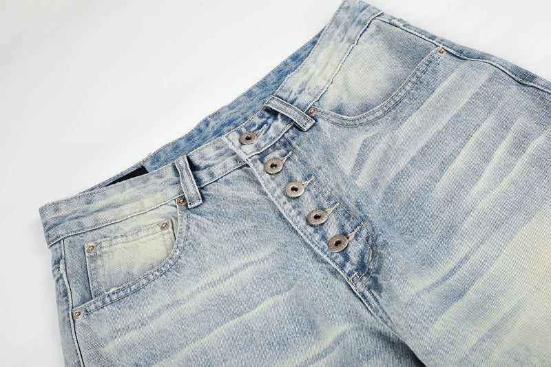 Close-up of the waistband and button fly on light wash denim jeans