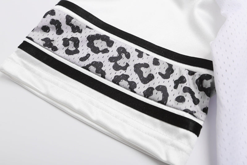 White varsity football jersey sleeve with black trim and leopard print panel, close-up streetwear detail