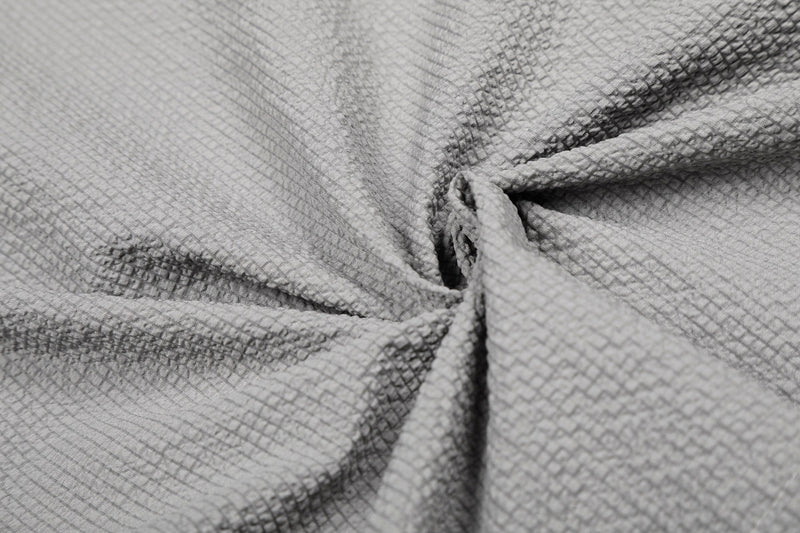 Close-up of textured gray cotton shirt fabric with asymmetrical folds and a minimalist streetwear look