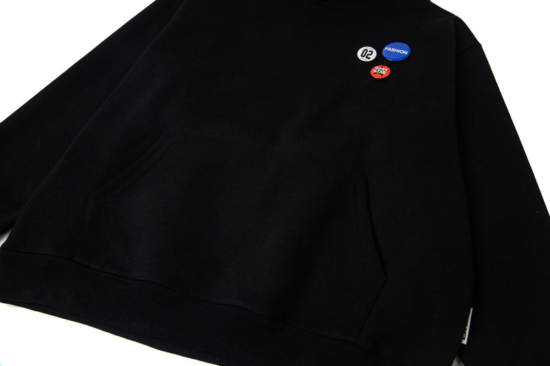 Black hoodie front with badge accents and kangaroo pocket detail