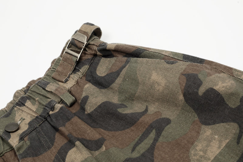 Close-up of waistband buckle and top seam on green brown camo shorts
