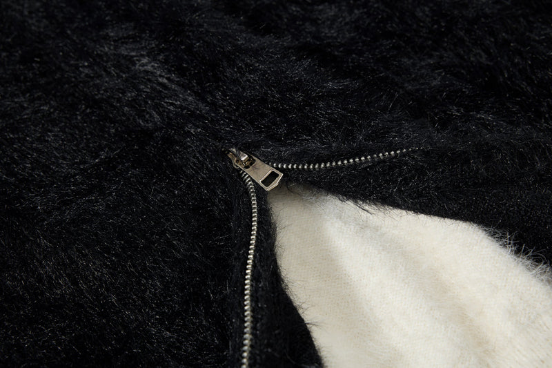 Close-up of front zipper and white lining on black fuzzy hoodie